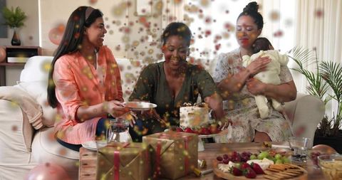 Friends celebrating baby shower with cake cutting, gifts, balloons and strawberries