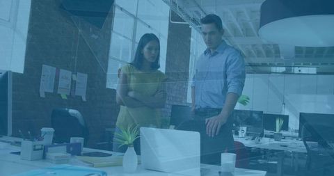 Office colleagues collaborating over project in modern workspace