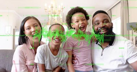 Joyful family sitting on gray sofa with green data overlay conveying connected smart home life