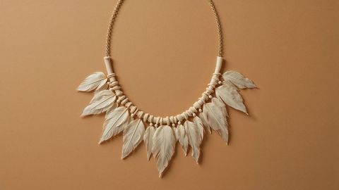 Artisan feather pendant necklace on earthy background