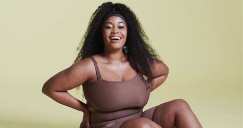 Joyful african american woman embracing confidence in minimal fashion