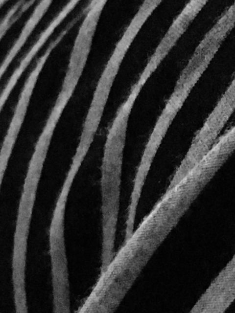 This black and white photo showcases a close-up view of striped fabric, highlighting the texture and pattern. Ideal for use in fashion design, graphic design backgrounds, and artistic projects focusing on fabric and textile patterns.