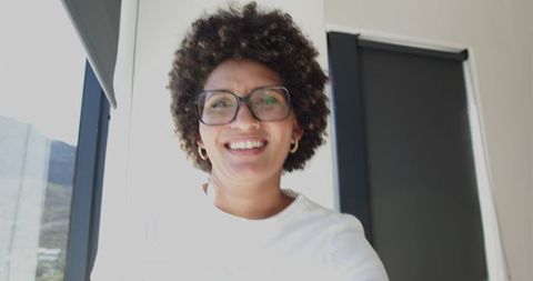 Confident Woman Smiling in Sunlit Home Office