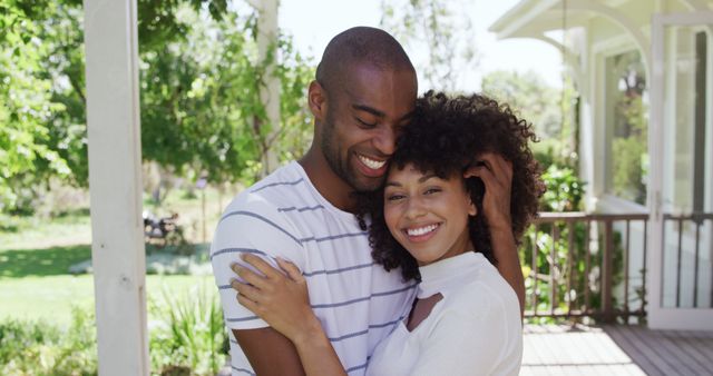 Smiling interracial couple hugging on porch on sunny day - Download Free Stock Images Pikwizard.com
