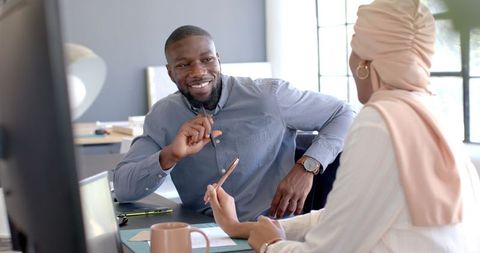 two colleagues engaging in an engaging discussion in an office, emphasizing teamwork and collaboration. suitable for illustrating corporate environments, team meetings, and business communication concepts.