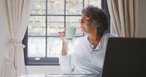 Senior Woman Enjoying Tea While Working From Home