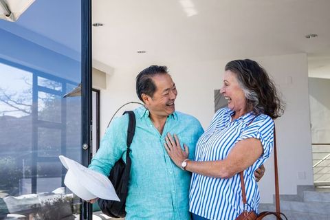 Happy Couple Laughing Together at Modern Home Entrance