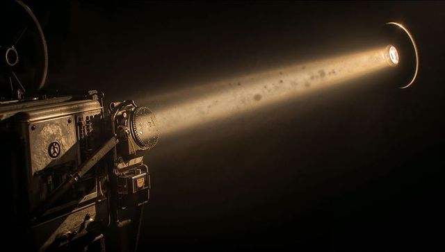 Vintage Film Projector Casting Strong Beam in Dark