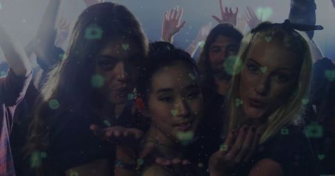 Friends blowing kisses at vibrant nightclub with heart icons overlay