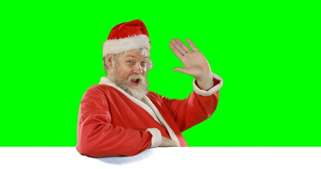 Elderly man in classic red and white Santa Claus outfit, smiling and waving with one hand, on a green screen background. Used for Christmas advertisements, festive greeting cards, promotional holiday materials, or video overlays.