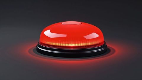Glowing red alert button on dark surface for interface design