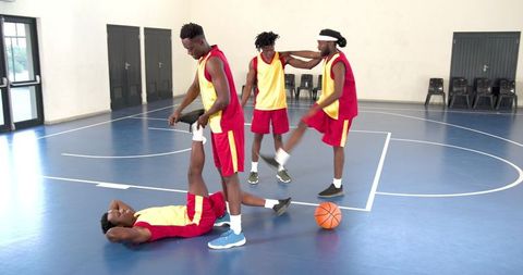 Basketball Team Stretching in School Gym with Orange Ball