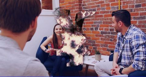 Smiling woman gesturing during casual team conversation in modern urban office lounge