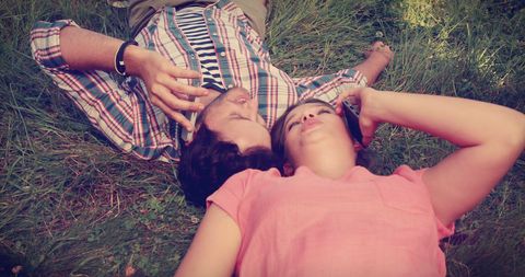 Middle-aged couple relaxing on grass sharing peaceful moment