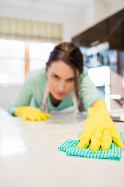 Close-up of woman cleaning kitchen worktop at home
