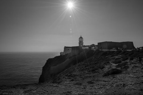 Silhouette of Lighthouse at Sunset by the Ocean Cliff