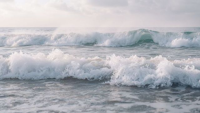 Pastel ocean waves rolling toward shoreline with surf foam and cresting swells