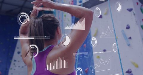 Woman Analyzing Data on Climbing Wall with Digital Interface