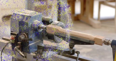 Turning wooden spindle on blue lathe for handcrafted furniture and woodturning projects