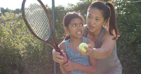 Mother Teaching Daughter Tennis Outdoors Summer Moment
