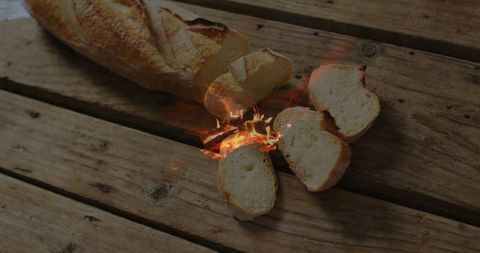 Crackling Baguette Loaf with Flames on Rustic Wooden Surface