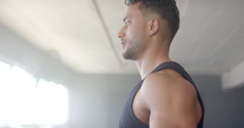Focused Man Working Out in Modern Gym, Side View