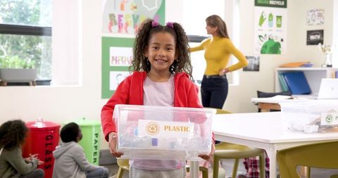 Girl promoting recycling in a bright modern classroom