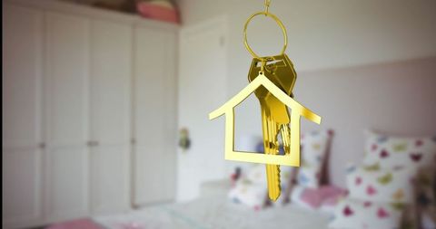 Golden House-Shaped Keyring Hanging in Modern Bedroom
