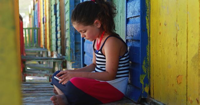 Young Girl Relaxing with Smartphone by Colorful Wooden Walls - Download Free Stock Images Pikwizard.com