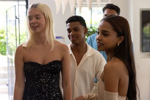 Diverse Group Celebrating in Decorated Living Room Near Glass Door