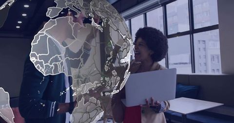 Professional colleagues collaborating in modern coworking lounge with digital globe overlay