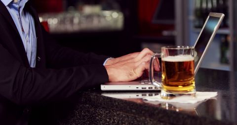 Businessman Balancing Work and Relaxation at Bar - Download Free Stock Images Pikwizard.com