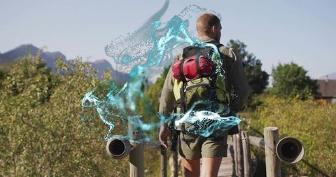 Hiker walking on boardwalk carrying backpack with blue particle trail in mountain nature