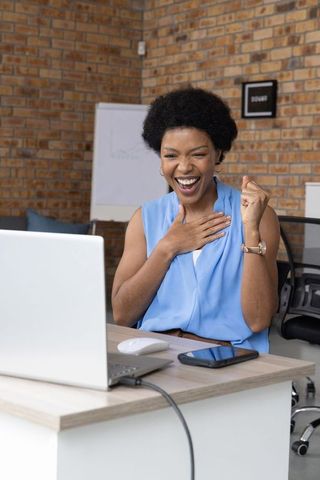 Professional woman celebrating success at modern workspace