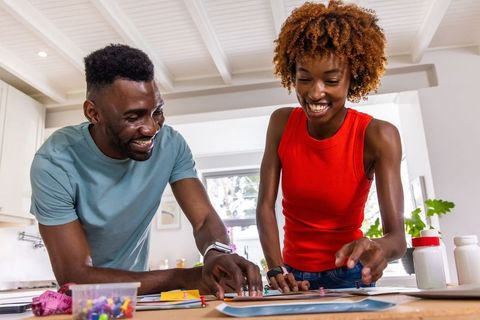 African american couple planning home diy project and crafting design in bright sunlit kitchen
