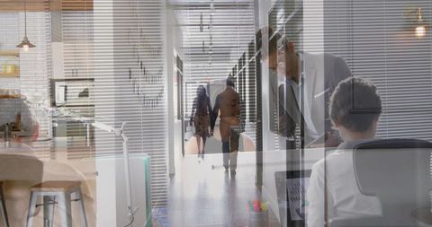 Walking professional woman moving through modern office corridor with layered workspace