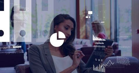 Businesswoman tapping tablet and reviewing digital charts in modern lounge