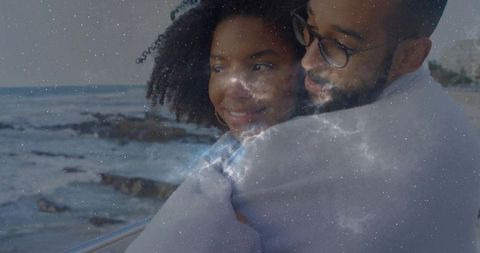 Couple Embracing on Coastline with Galaxy Overlay Conveying Dreamy Romance
