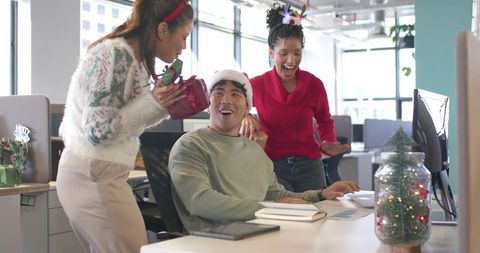 Office Holiday Surprise Celebrating Asian Coworker in Santa Hat with Gifts and Laughter