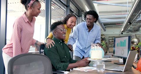 Colleagues celebrate birthday in modern office environment