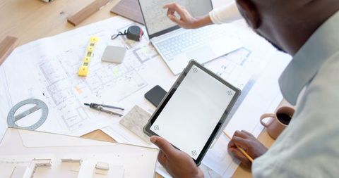 Business Professionals Collaborating with Tablet and Blueprints