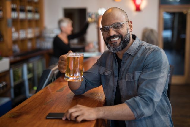 Portrait of happy man having glass of beer in bar