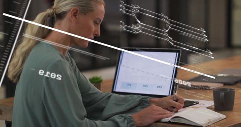 Woman writing in modern co-working space with ambient overlays