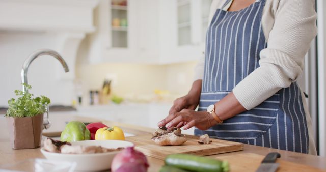 Woman Wearing Striped Apron Chopping Vegetables in Kitchen - Download Free Stock Images Pikwizard.com