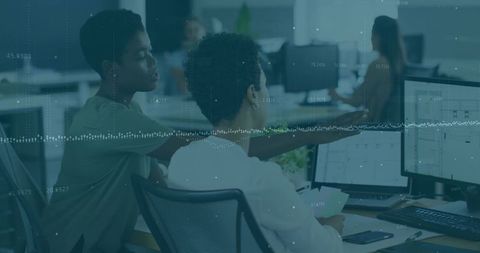 Focused coworkers collaborating on data analysis on monitors