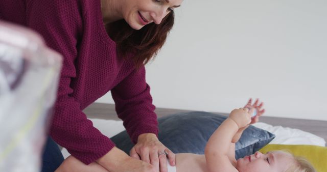 Mother Changing Baby's Diaper in Cozy Home Setting - Download Free Stock Images Pikwizard.com