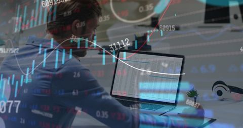 Man Analyzing Stock Market Data on Laptop in Office Environment
