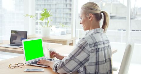 Middle-Aged Woman Working on Laptop with Green Screen - Download Free Stock Images Pikwizard.com