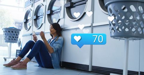 Young Woman Receiving Social Media Notifications in Laundry Room