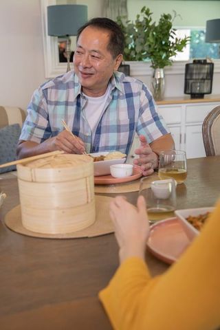 Asian Family Enjoying Traditional Meal with Steamer Basket at Home